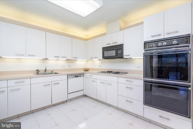 kitchen with black appliances, white cabinetry, and sink