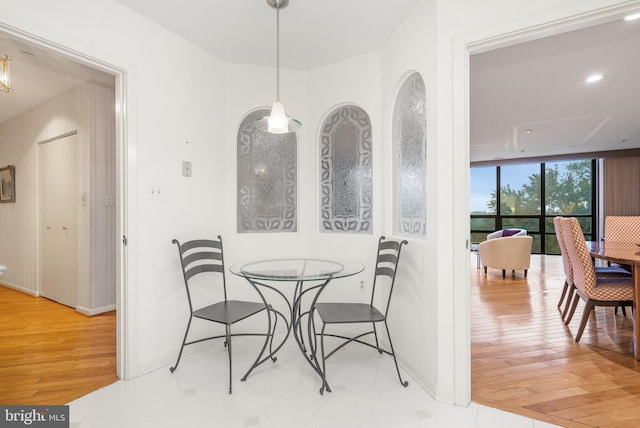 dining area with light wood-type flooring and a wall of windows