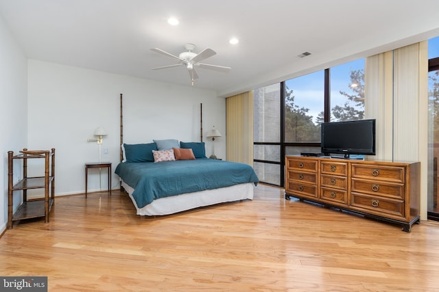 bedroom featuring expansive windows, light hardwood / wood-style flooring, and ceiling fan