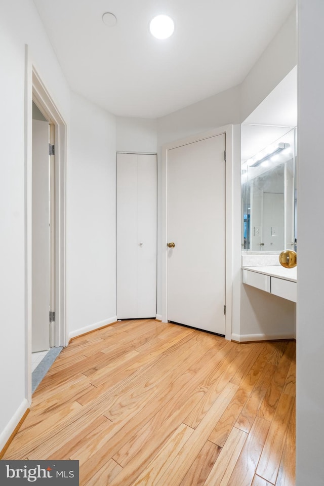 unfurnished bedroom featuring light wood-type flooring and ensuite bath