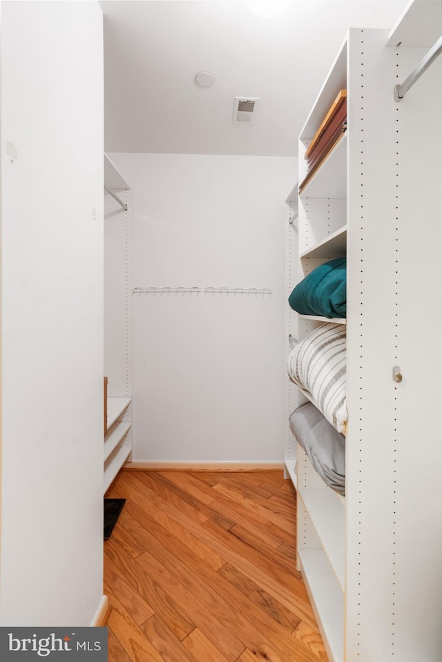 spacious closet with hardwood / wood-style flooring