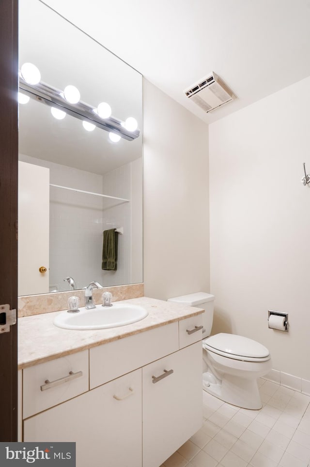 bathroom featuring tile patterned flooring, vanity, toilet, and walk in shower