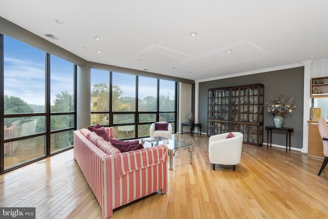 living room with light hardwood / wood-style floors and a wall of windows