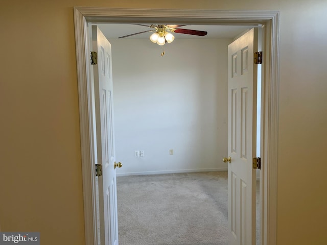 hallway with carpet floors and baseboards