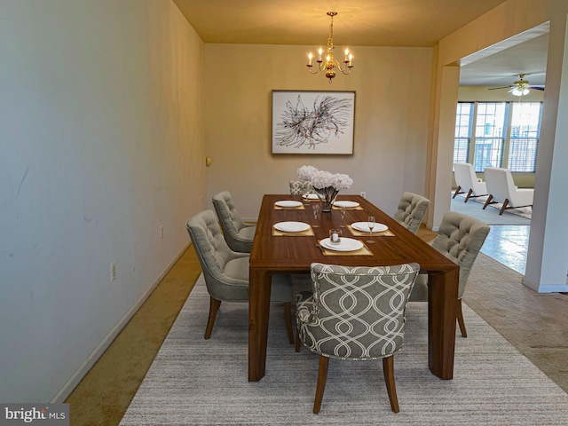 carpeted dining space featuring baseboards and a notable chandelier