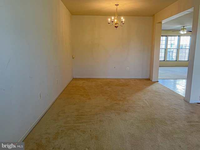 empty room featuring an inviting chandelier, carpet, and baseboards