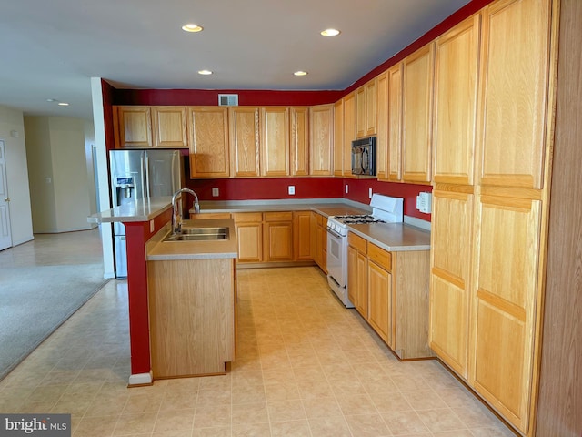 kitchen with white range with gas stovetop, visible vents, a center island with sink, black microwave, and a sink