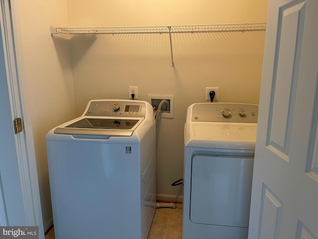 washroom with light tile patterned floors and washing machine and dryer