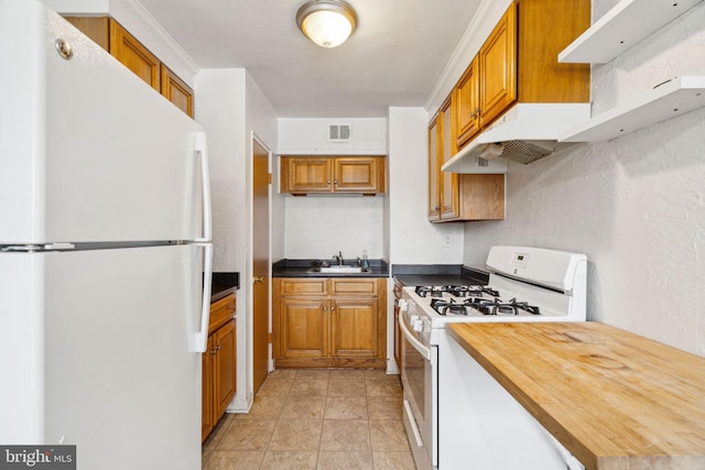 kitchen featuring butcher block countertops, white appliances, and sink