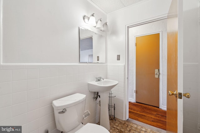 bathroom featuring tile walls, sink, and toilet