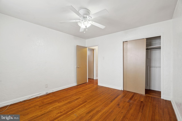 unfurnished bedroom featuring hardwood / wood-style floors, ceiling fan, and a closet