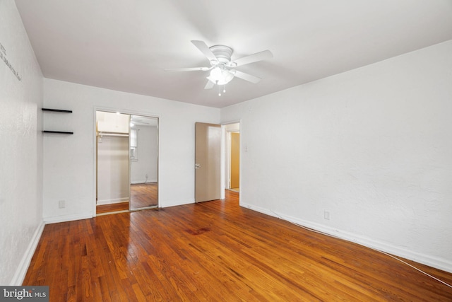 unfurnished bedroom featuring hardwood / wood-style floors, ceiling fan, and a closet