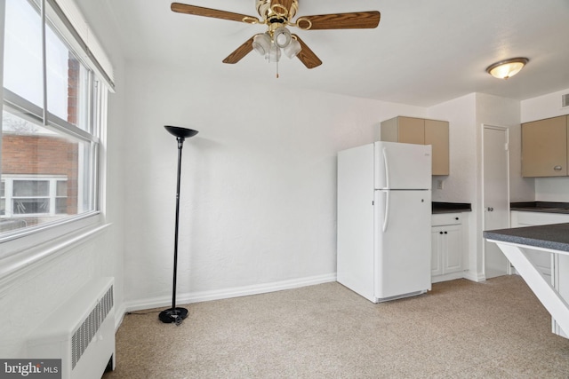 kitchen featuring ceiling fan, light colored carpet, radiator, and white fridge