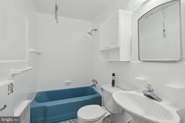 full bathroom with sink, radiator, tile walls, tiled shower / bath combo, and toilet