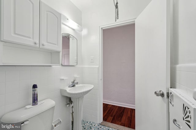 bathroom with tile walls, hardwood / wood-style flooring, and toilet