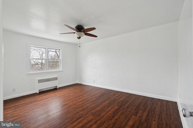 unfurnished room featuring ceiling fan, radiator, and dark hardwood / wood-style flooring