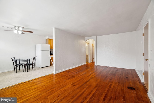 unfurnished living room featuring ceiling fan and light wood-type flooring