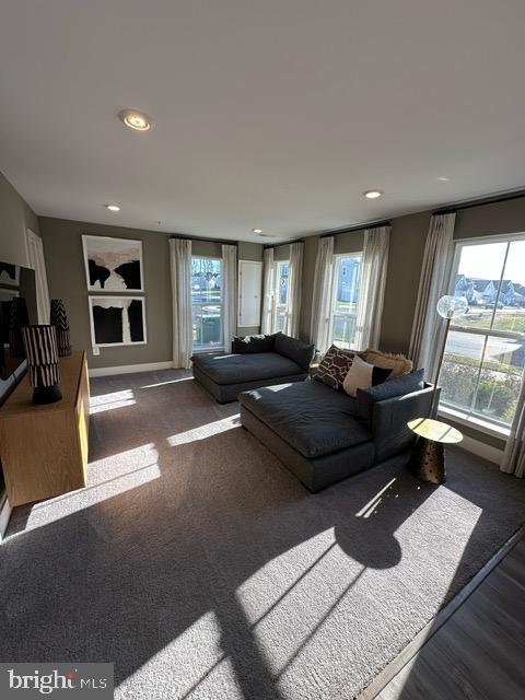 living room featuring dark hardwood / wood-style flooring and a healthy amount of sunlight