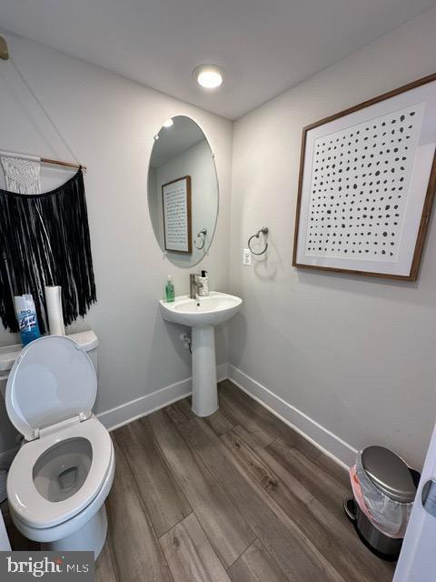 bathroom with sink, wood-type flooring, and toilet