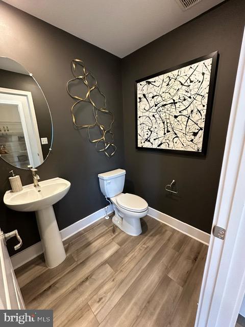 bathroom featuring wood-type flooring and toilet