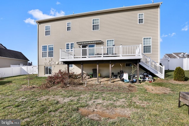 rear view of house with a lawn and a wooden deck