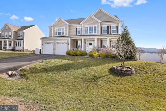 view of front of property with a front lawn, covered porch, and a garage