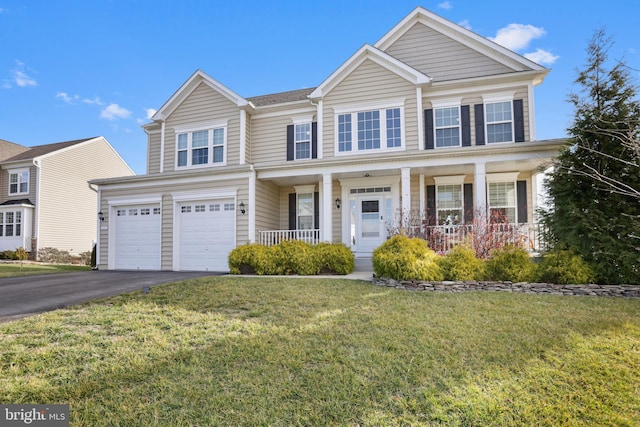 view of front of property featuring covered porch, a front yard, and a garage