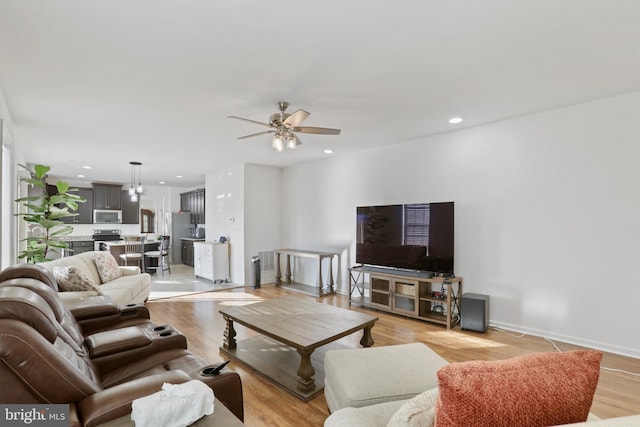 living room featuring ceiling fan and light wood-type flooring