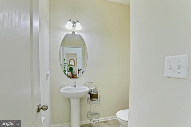 bathroom with tile patterned flooring, toilet, and sink