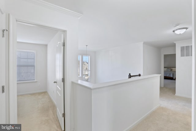 hallway featuring light colored carpet and crown molding