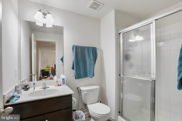 bathroom with vanity, toilet, and a shower with shower door