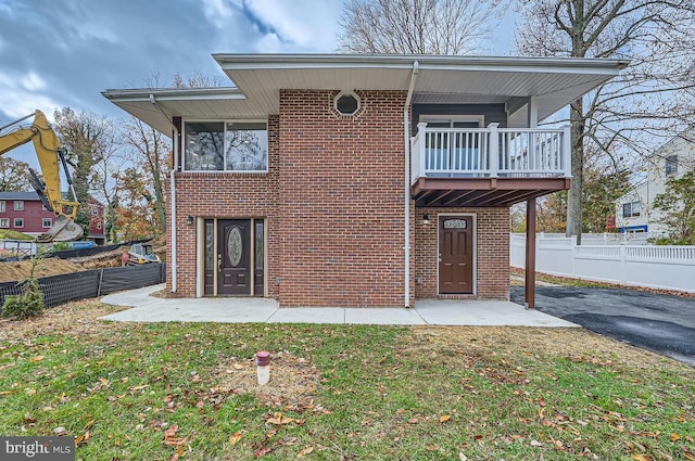 view of front of property featuring a front yard and a balcony