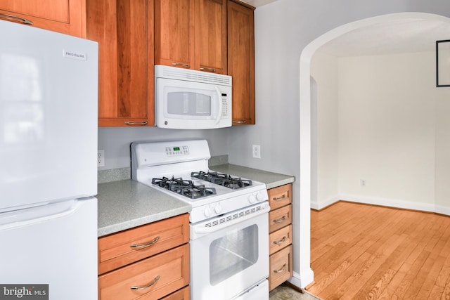 kitchen with white appliances and light wood-type flooring