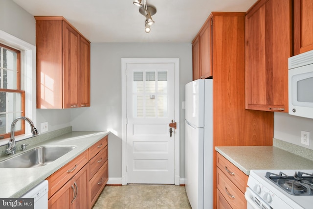 kitchen with sink, white appliances, and a healthy amount of sunlight