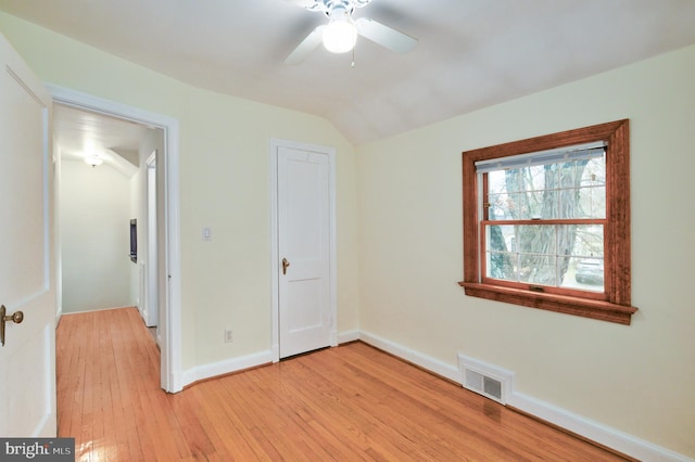 unfurnished bedroom with ceiling fan, light hardwood / wood-style floors, a closet, and lofted ceiling