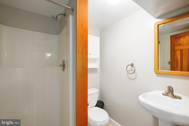 bathroom with sink, toilet, and a shower