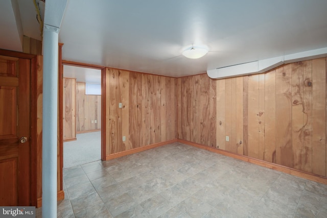 carpeted empty room with wood walls