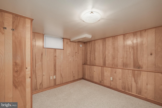 basement featuring wooden walls and light carpet