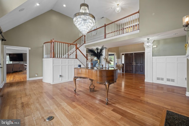 foyer featuring a chandelier, light wood-type flooring, and high vaulted ceiling