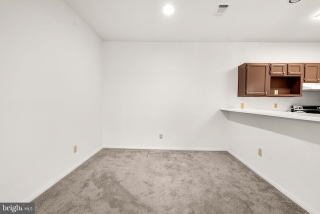 kitchen featuring light colored carpet and electric range