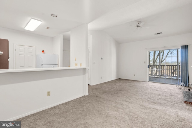 unfurnished living room with ceiling fan, carpet flooring, and vaulted ceiling