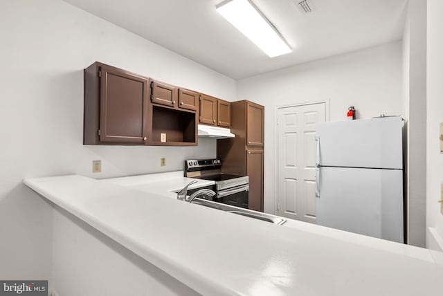 kitchen featuring white refrigerator, sink, kitchen peninsula, and stainless steel range with electric stovetop