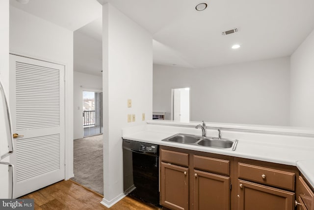 kitchen featuring dishwasher, sink, light hardwood / wood-style floors, and kitchen peninsula