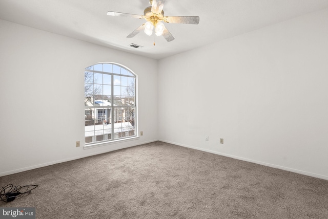 carpeted spare room featuring ceiling fan and a healthy amount of sunlight