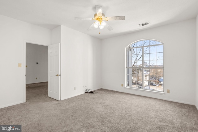 empty room featuring light colored carpet and ceiling fan