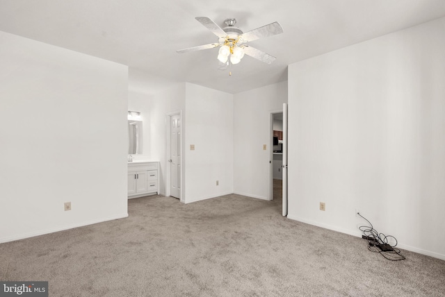 unfurnished bedroom with ensuite bathroom, light colored carpet, and ceiling fan