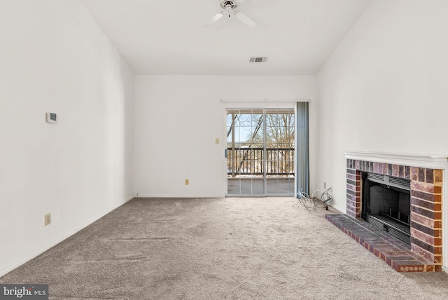 unfurnished living room featuring carpet, ceiling fan, and a brick fireplace