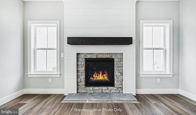 room details with hardwood / wood-style floors and a stone fireplace