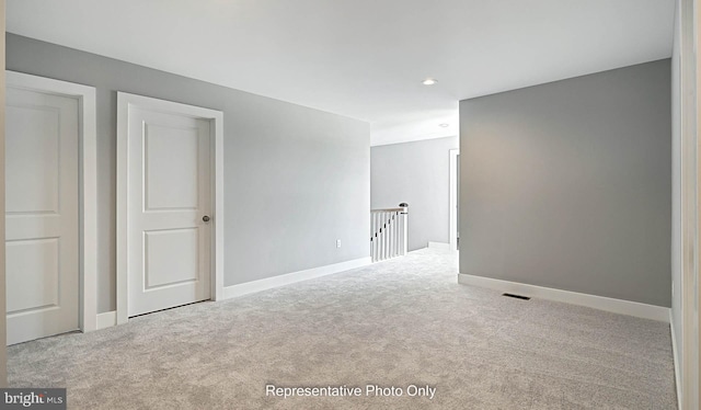 unfurnished room featuring light carpet