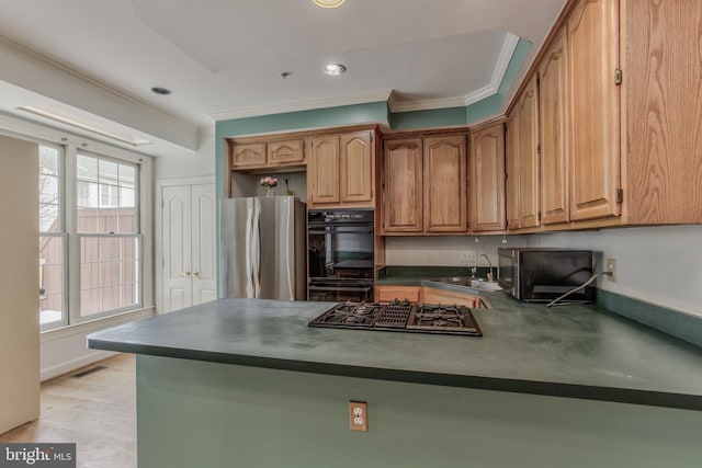 kitchen with gas cooktop, double oven, kitchen peninsula, and stainless steel refrigerator